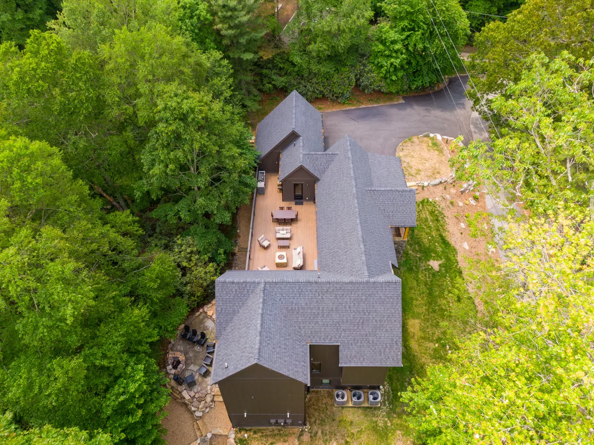 A generous view of the home’s deck, highlighting comfortable outdoor seating and lush greenery all around. The space looks ideal for socializing or enjoying a quiet morning coffee, reinforcing the home’s connection to nature and outdoor living.